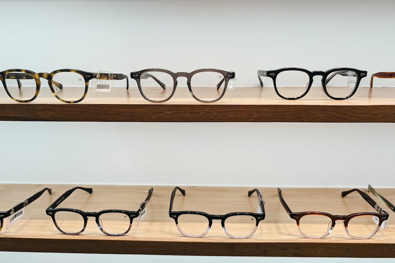 Showcase of stylish eyeglasses on wooden shelves, highlighting modern eyewear design and clear vision.